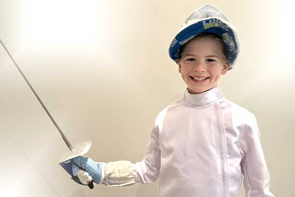 Smiling Fencing Student in Fencing Uniform at Fencing School CLE